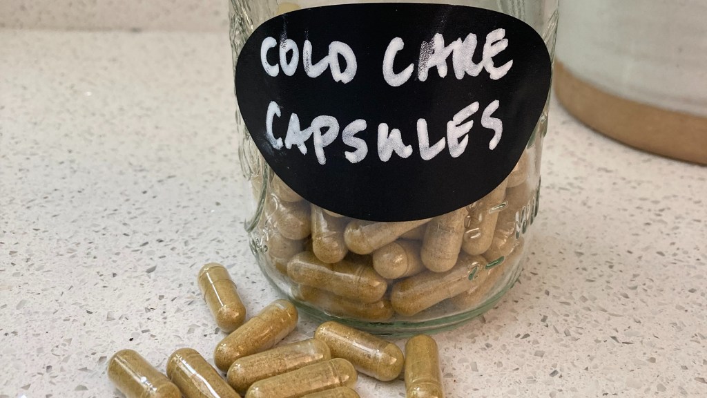 close up of cold care capsules in a jar and on the counter