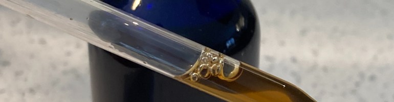 Blue bottle with dropper filled with brown liquid herbal tincture